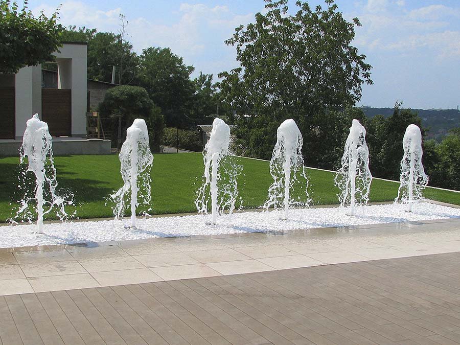 Linear Ground Jet Fountain Linear ground water jets in a modern landscaped courtyard