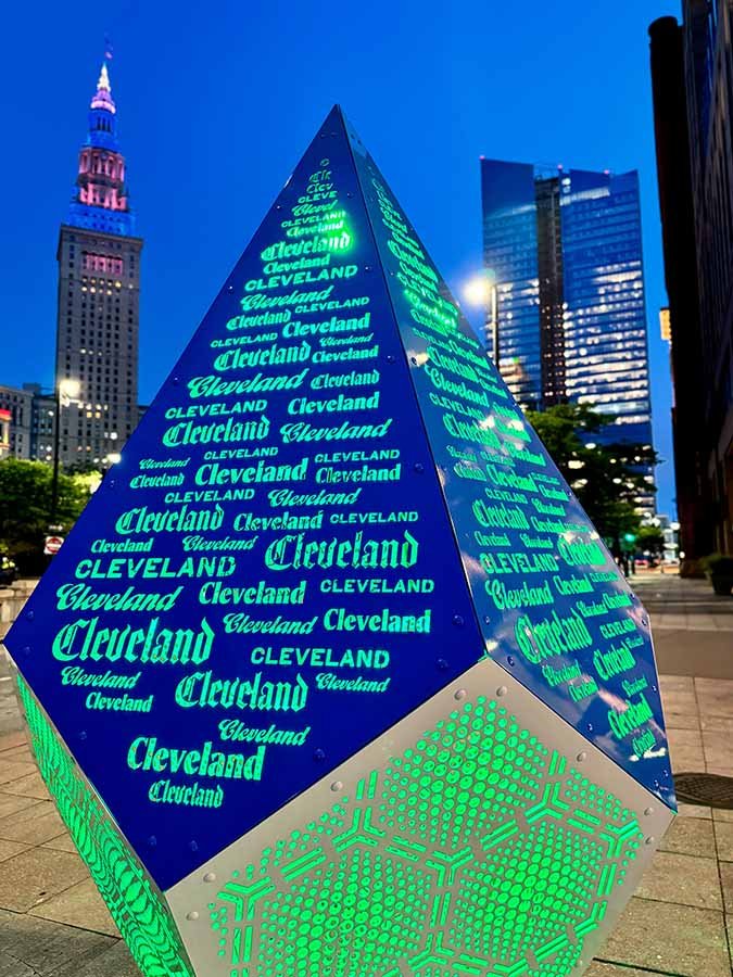 Illuminated public art landmark featuring Cleveland typography Illuminated Cleveland landmark sculpture at night