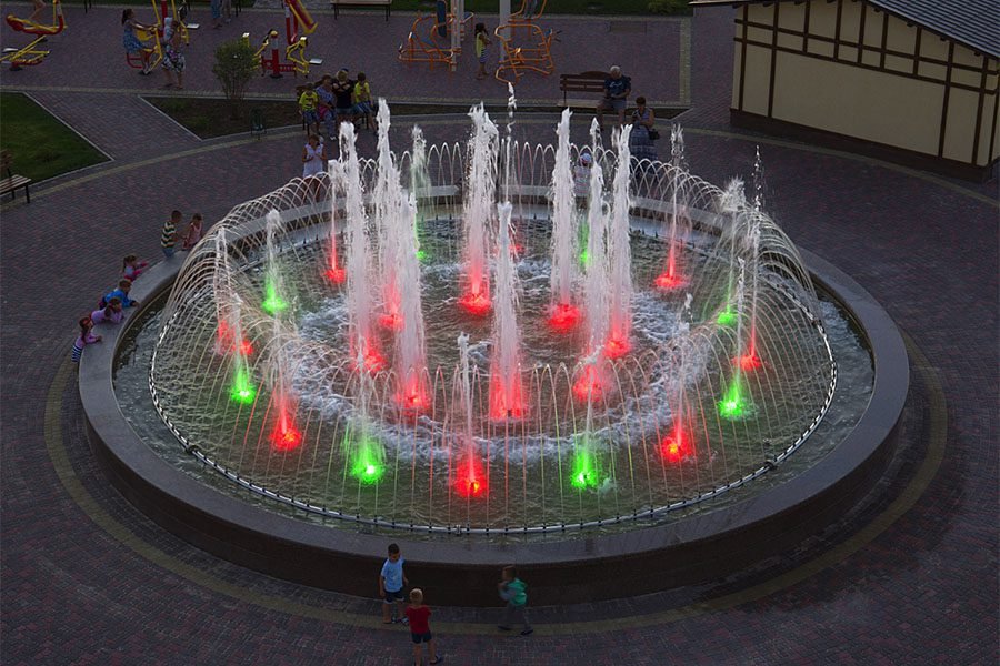 Public circular fountain with multi-level water jets and lighting Public circular fountain with multi-level water jets and lighting