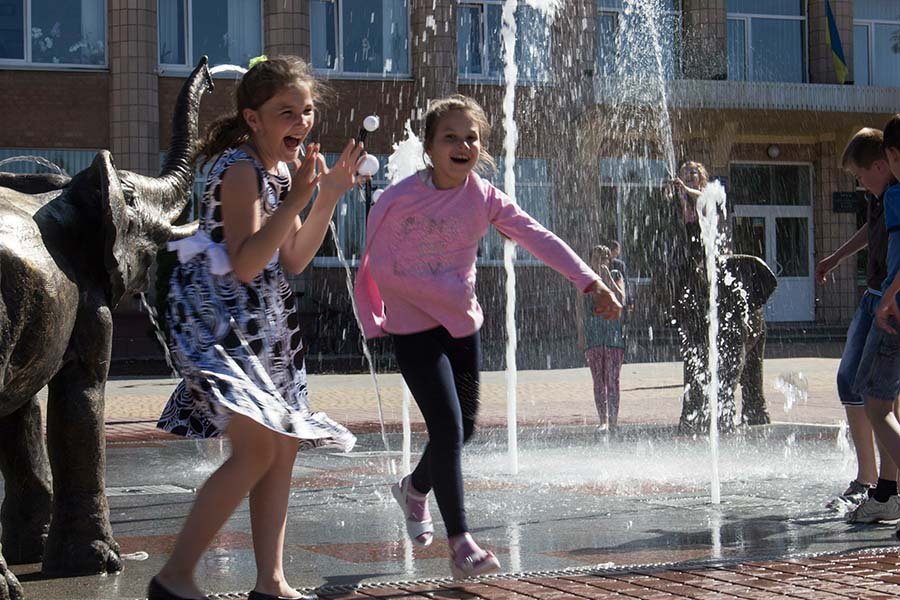 Interactive dry-deck fountain installation for urban public spaces — modern water feature for city plazas Interactive dry-deck fountain in public space with children playing