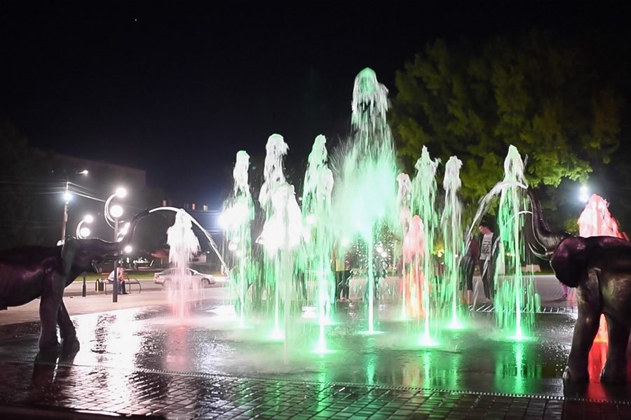 Interactive public fountain installation with dynamic LED lighting and sculptural features for urban plazas and municipal landscape projects nteractive LED fountain with sculptural elements at night