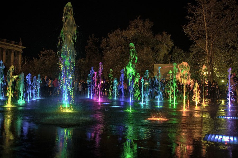 Interactive LED fountain with vertical jets and multicolor lighting effects in public park interactive LED fountain
