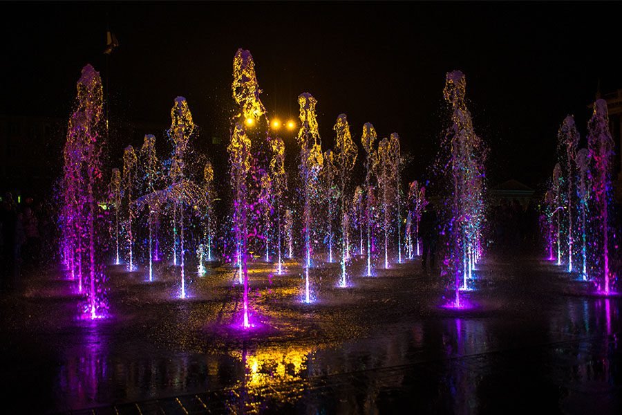 Dancing water fountain with synchronized jets and colorful LED lighting at night dancing water fountain