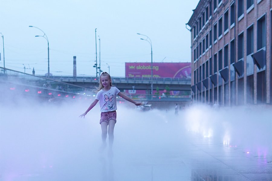 Girl in fog Girl runs in the fog along a fountain during the day