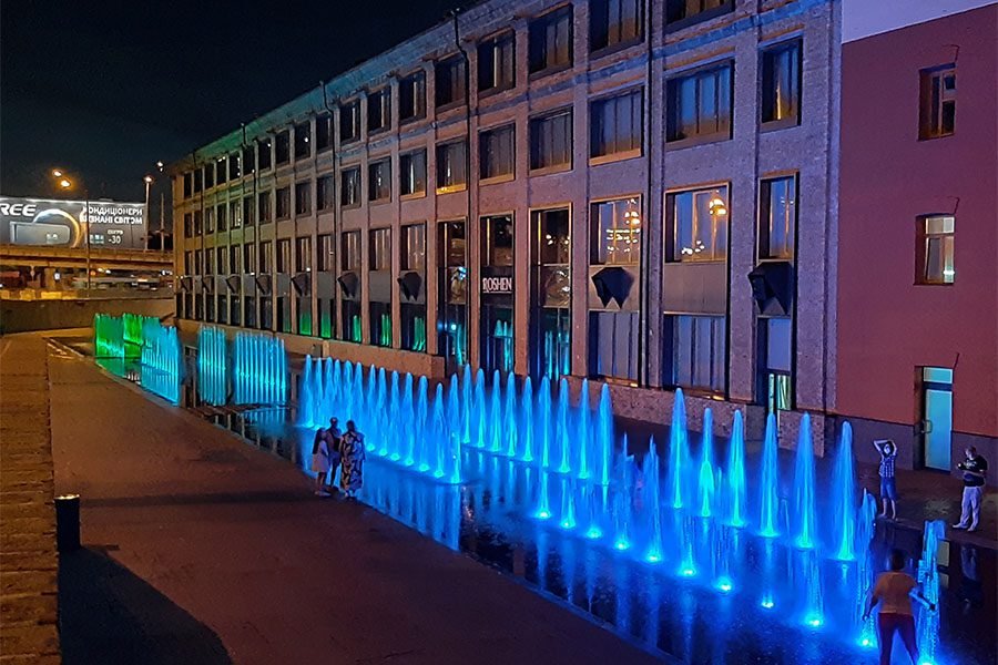Fonatan in full mode Illuminated pedestrian fountain with raised jets of 2 meters at night in which children run
