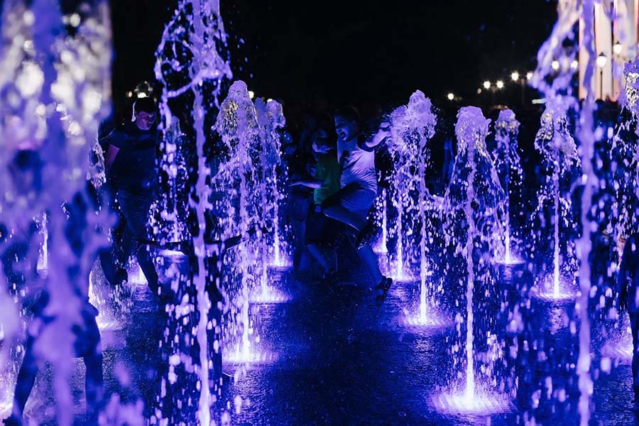 water jets with light in public park water jets at night with blue lighting