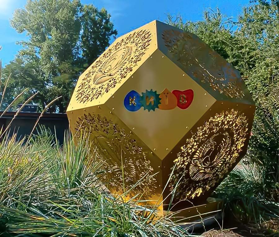 Gold Geometric Sculpture – custom outdoor metal art installation with laser-cut patterns and playful colorful branding Gold metal geometric art installation with perforated patterns outdoor