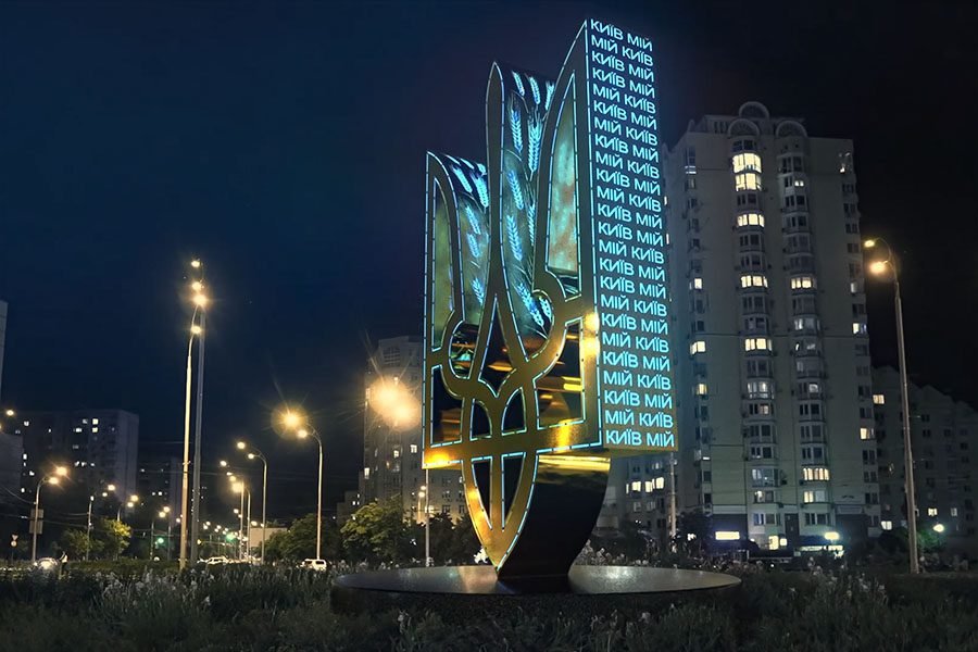 luminous metal Tryzub monument with dynamic Kyiv text projection — modern Ukrainian public art sculpture with LED lighting installed in a city square at night custom unique art sculpture on the Roundabout