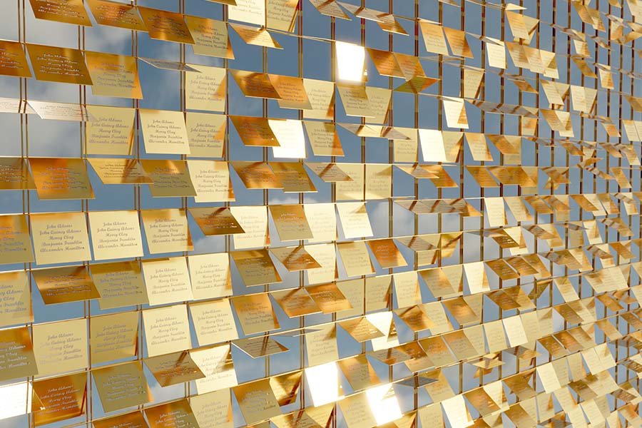 Sailboat Art Installation – detailed view of golden reflective panels forming the sails, each engraved with inscriptions and names, symbolizing connection and collective memory sailboat art installation detail with golden reflective engraved panels