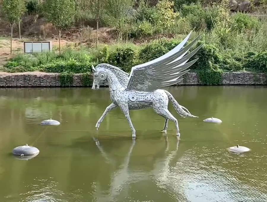 silver metal sculpture in the lake