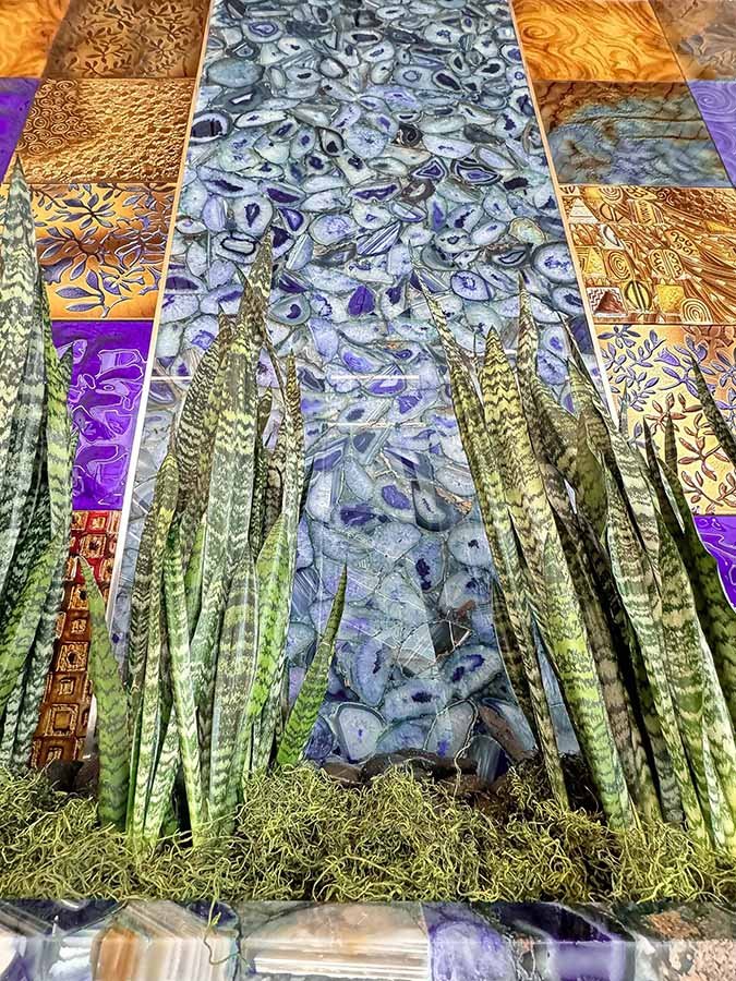 Waterfall glass-and-stone panel with live plants