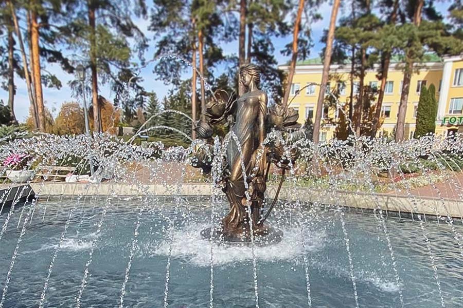 bronze female sculpture fountain with arched water jets