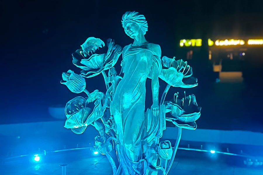 illuminated bronze woman sculpture fountain with floral elements