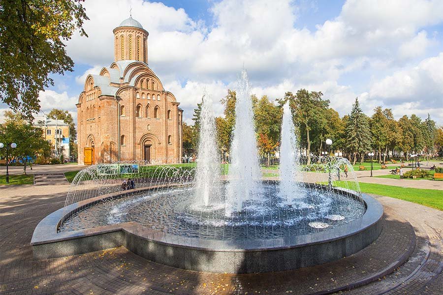 circular public fountain with tall water jets in city park