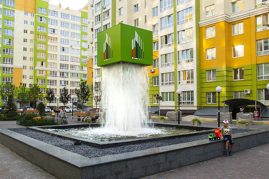 Modern architectural water feature with a cube waterfall installation in a residential courtyard