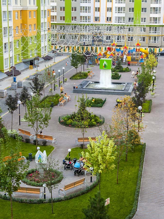 Unique cube-shaped waterfall structure creating a dramatic water feature in a modern residential complex