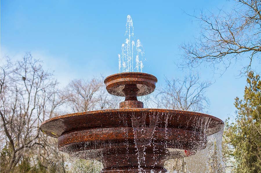 Top tier of classic stone fountain with cascading water