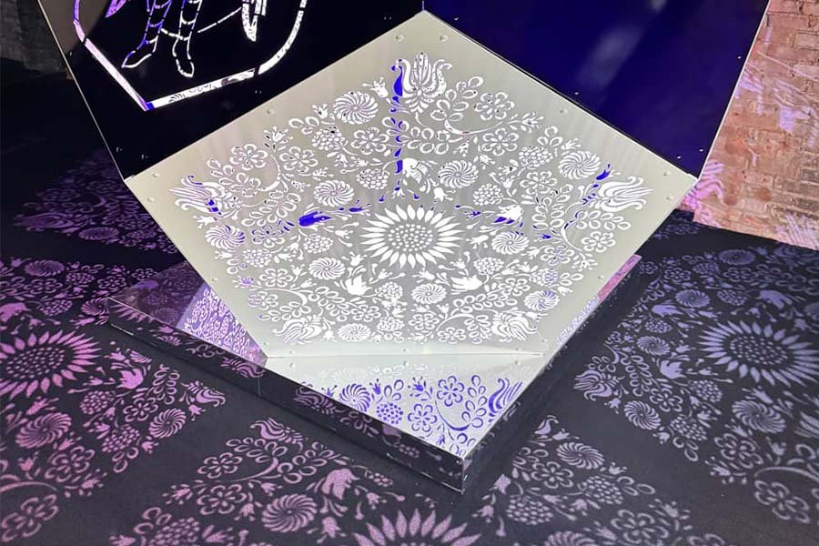 Decorative illuminated pattern projection from perforated metal panel
