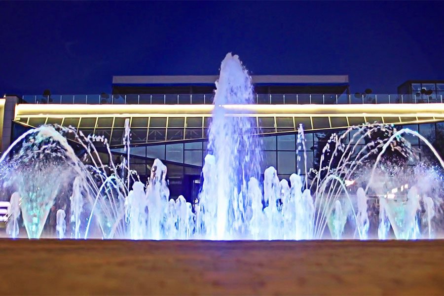 Night view of interactive LED fountain in front of modern building