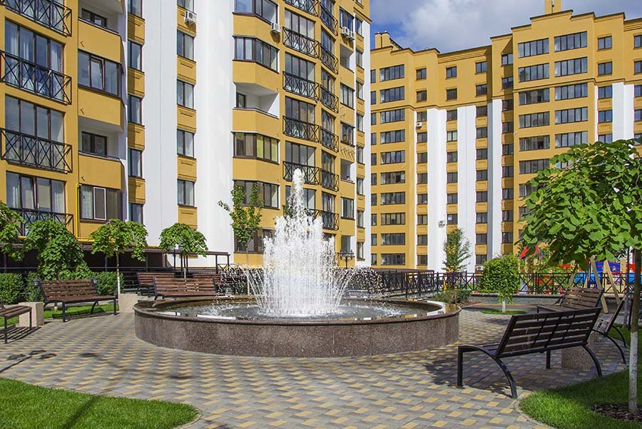 Architectural round fountain in a landscaped courtyard with seating