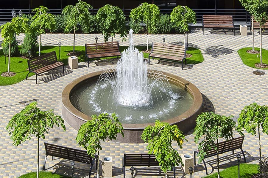 Courtyard fountain with central water jets in a landscaped residential complex