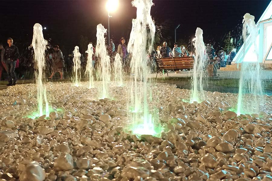 Ground water jets with green LED lighting in a public park at night