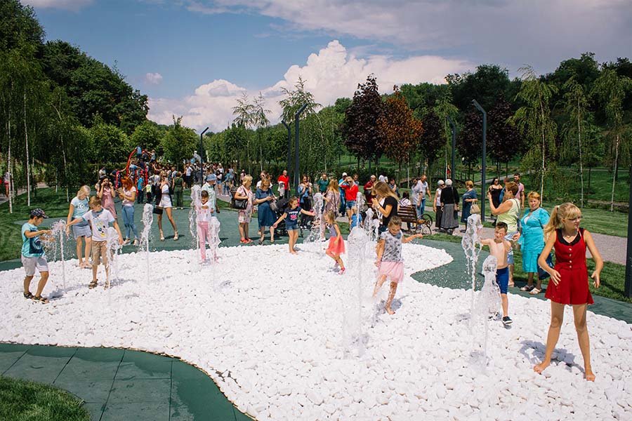 nteractive splash pad with children playing in a public park