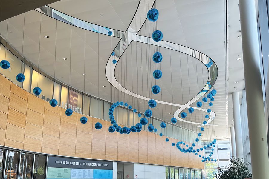 Kinetic art installation of suspended blue glass spheres