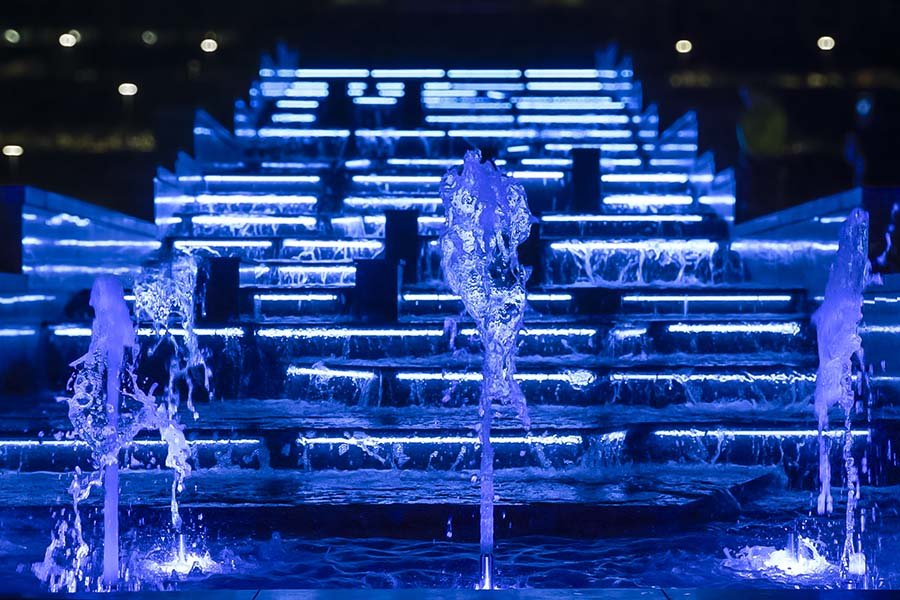 night view of architectural staircase fountain with blue lights