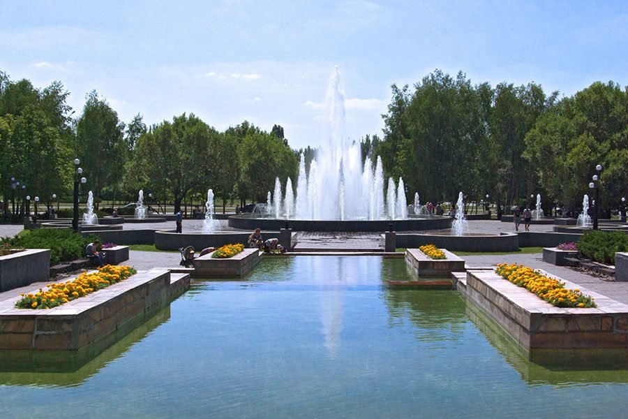Public fountain with central water jets in landscaped park