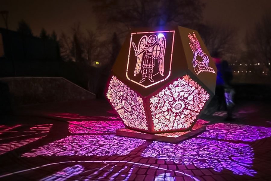 Illuminated metal art installation with engraving and floral LED projection patterns
