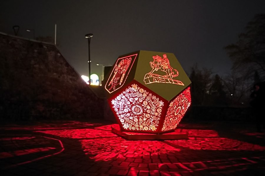 Laser-cut metal installation with integrated LED lighting projecting ornamental patterns