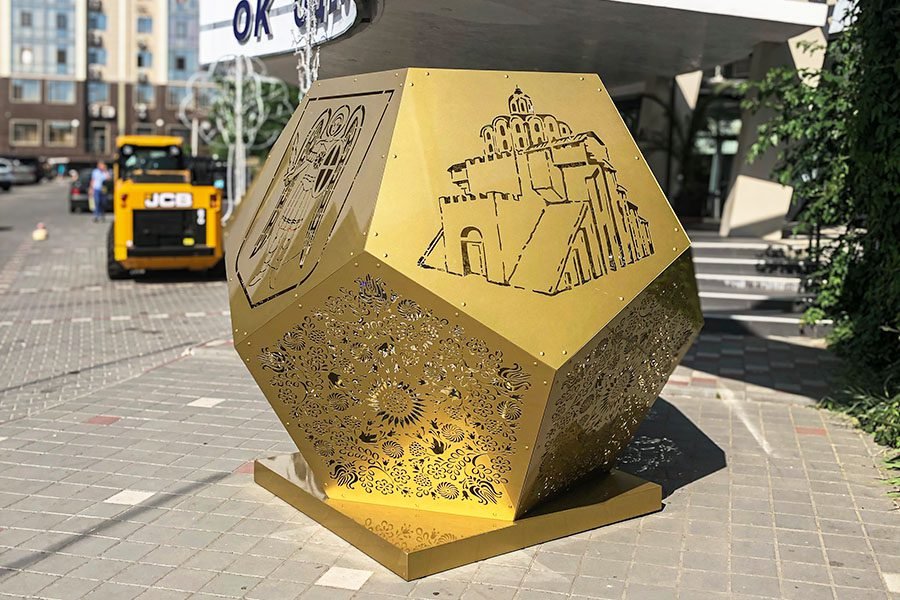 Gold geometric metal installation with laser-cut panels