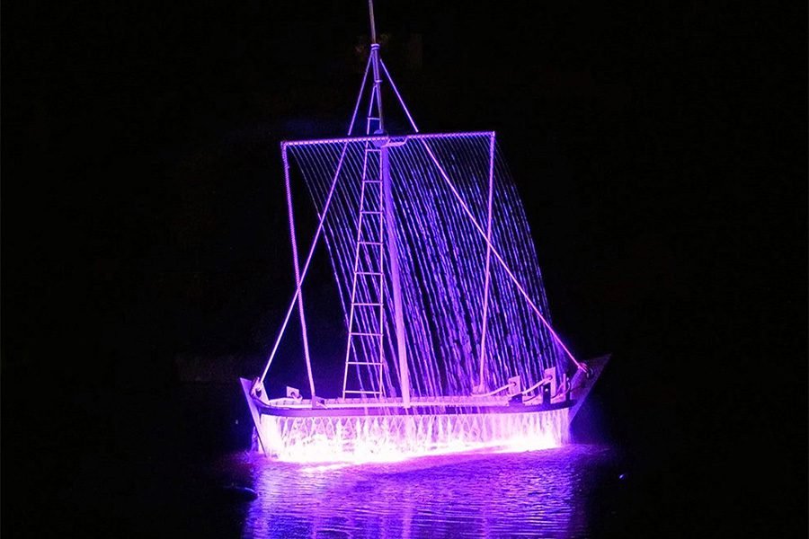 LED sailboat water fountain installation at night