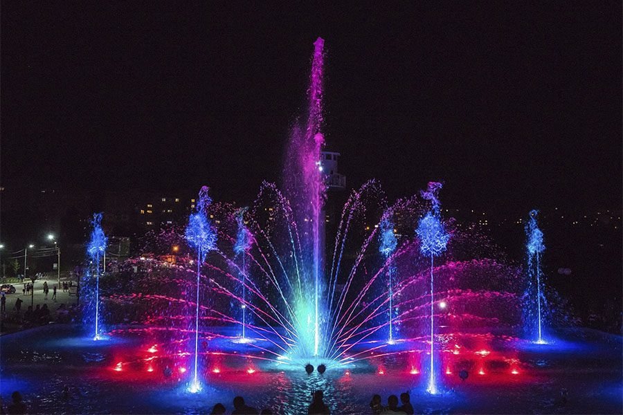 Musical fountain with blue and red LED water jets at night