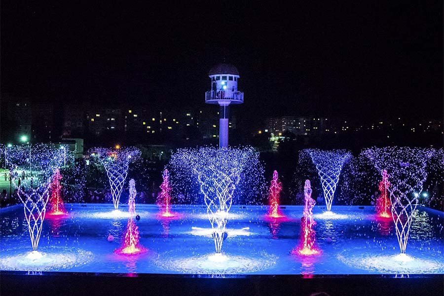 Musical fountain with LED spiral jets and colorful lighting at night