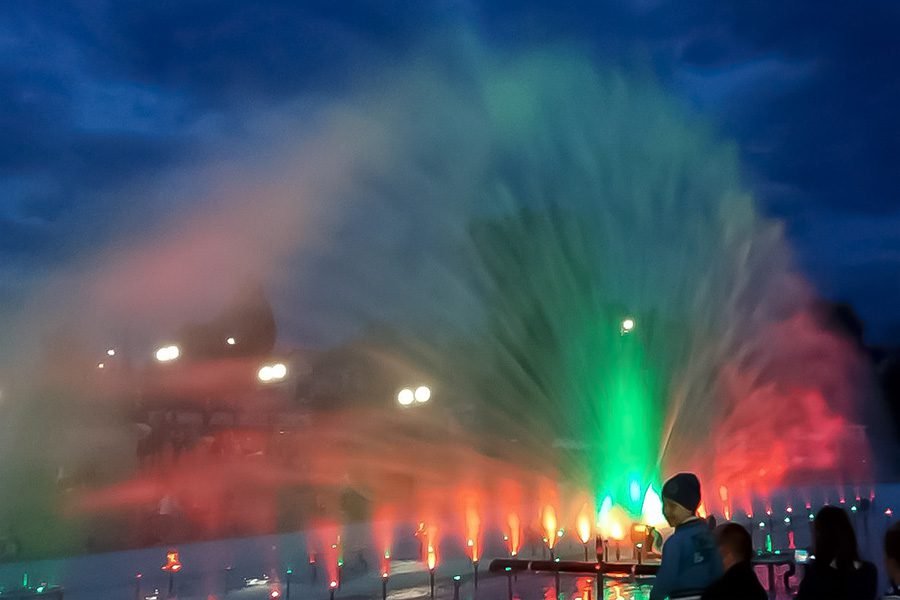 Colorful water screen projection fountain with LED lighting at dusk