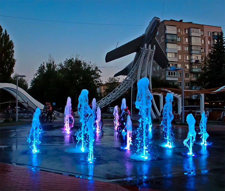 illuminated water jets at night with real airplane feature