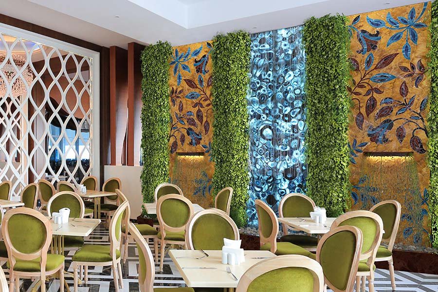 glass stone wall installation with gold panels and vertical greenery in luxury interior