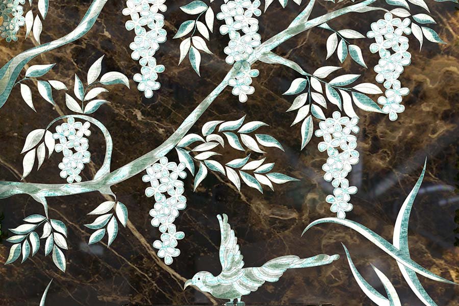 carved silver tree with birds on stone wall