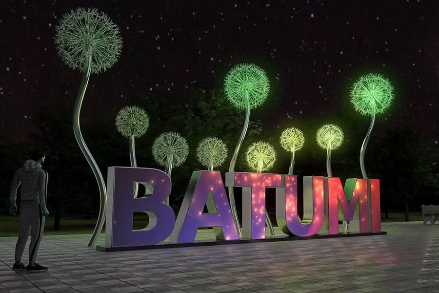 illuminated Batumi city sign with glowing dandelion sculptures at night