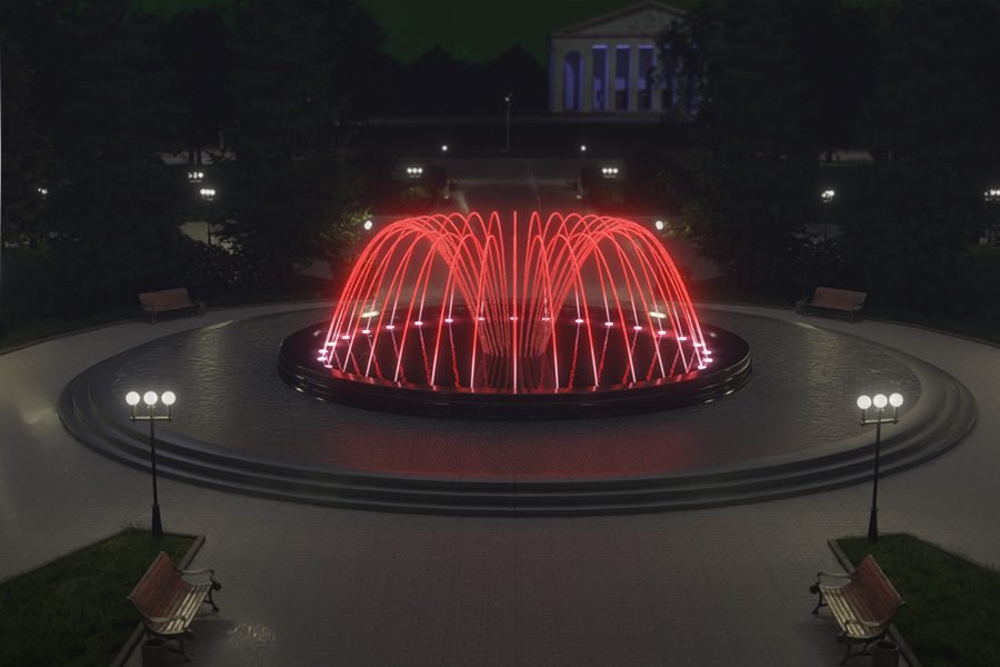 outdoor circular music fountain glowing at night