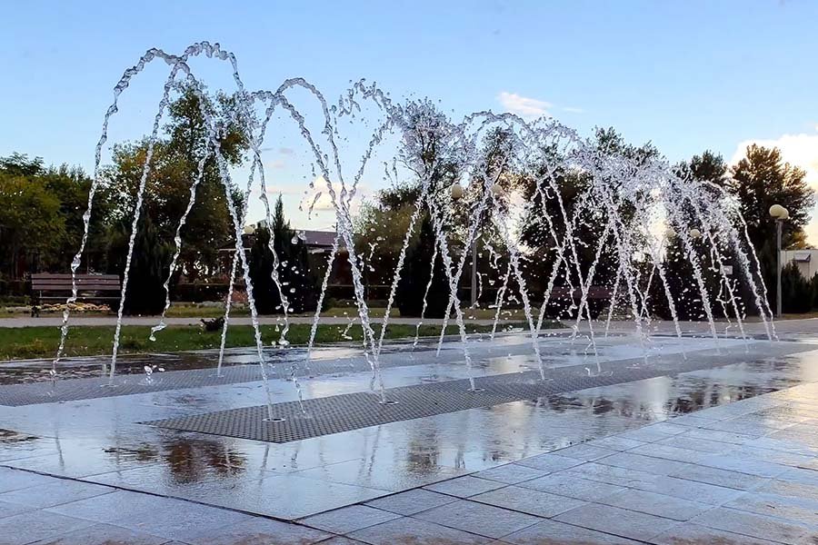 Public water fountain with symmetrical arched streams