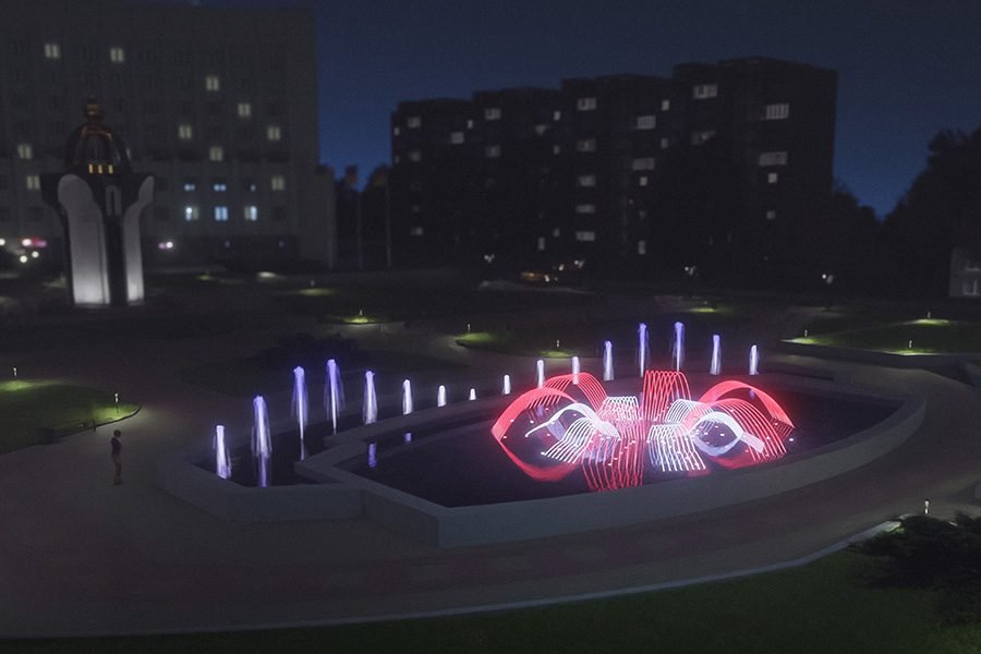 night water fountain with red and white illuminated jets in urban area