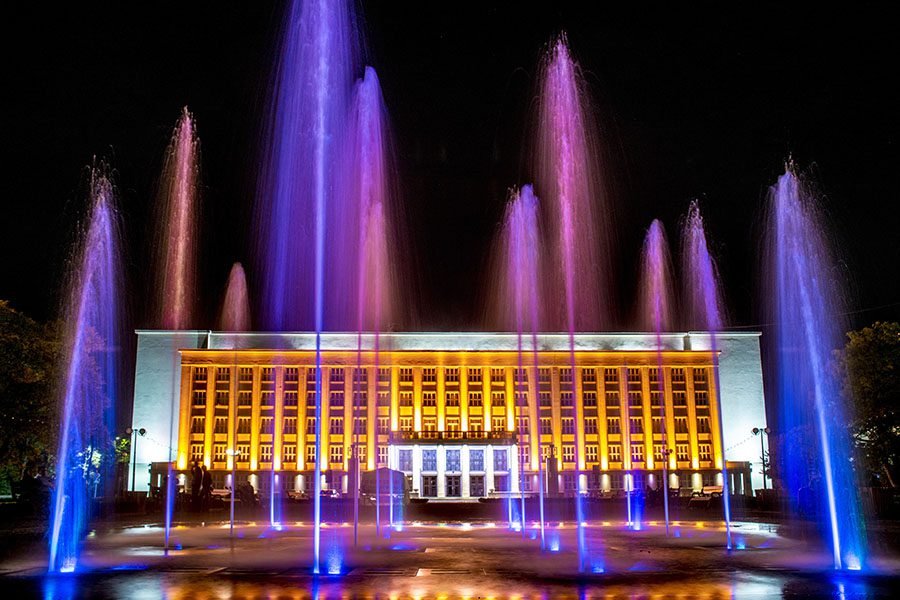 illuminated fountain show in front of government building at night