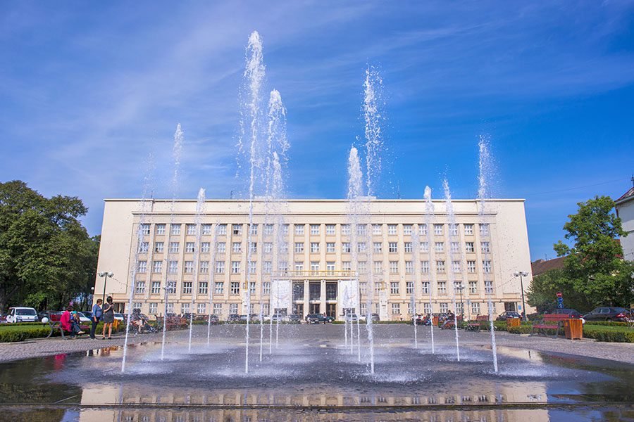 public square fountain with vertical water jets in front of government building