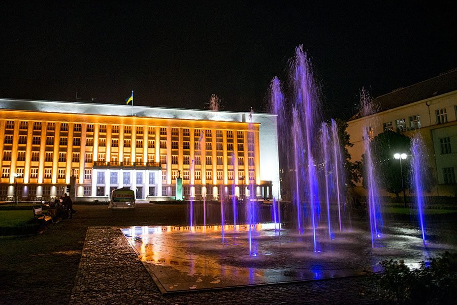 illuminated fountain jets in city square at night