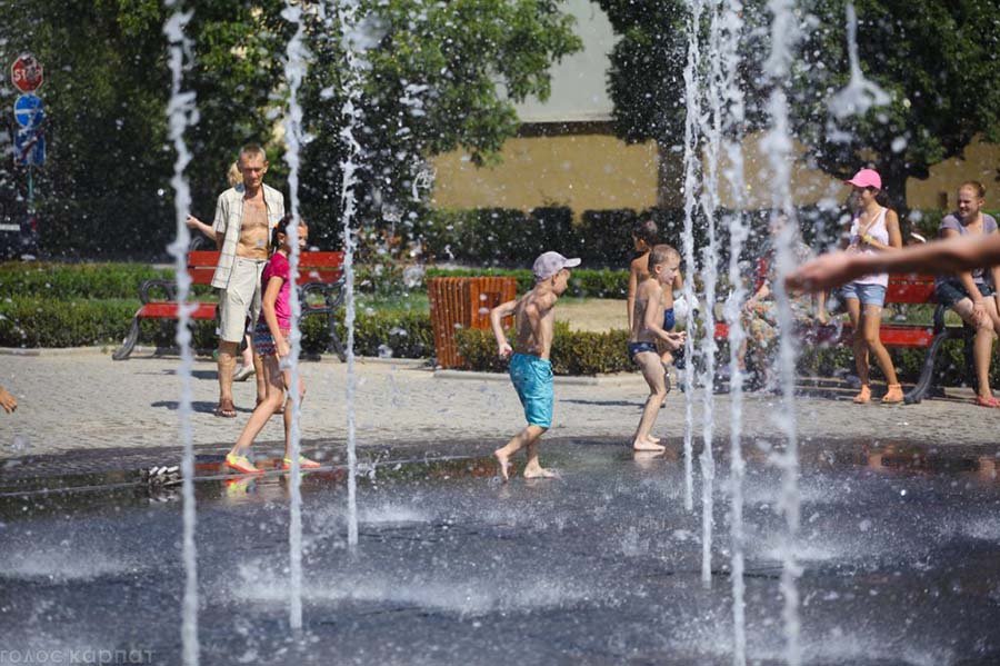 kids running through vertical fountain jets
