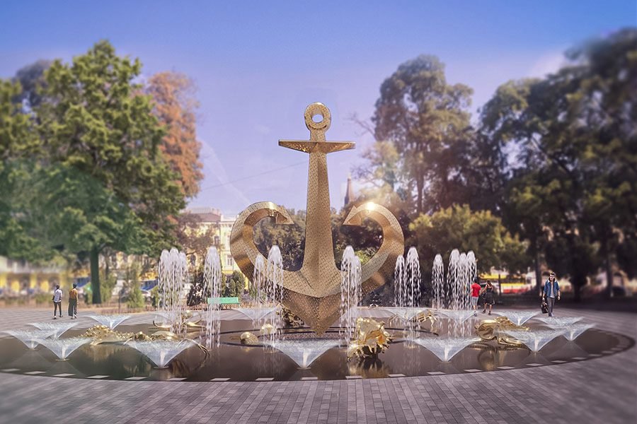 gold perforated anchor fountain with water jets in public park