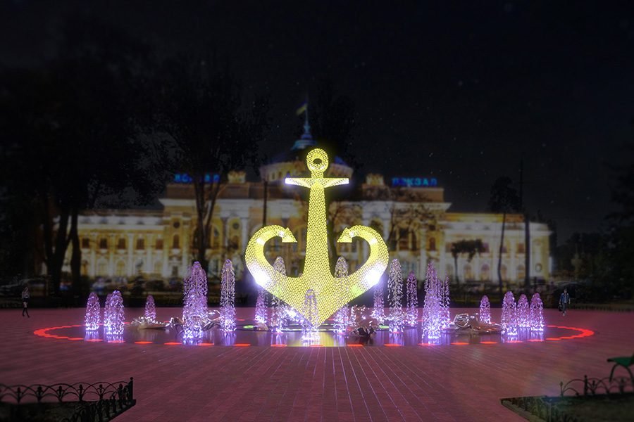 gold LED anchor fountain with illuminated water jets at night